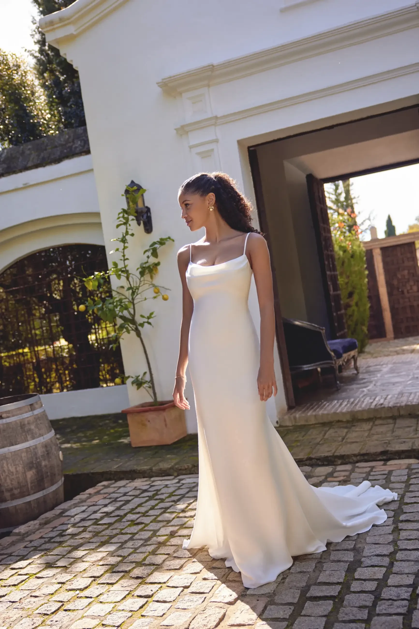 model is wearing a sleeveless sheath wedding dress