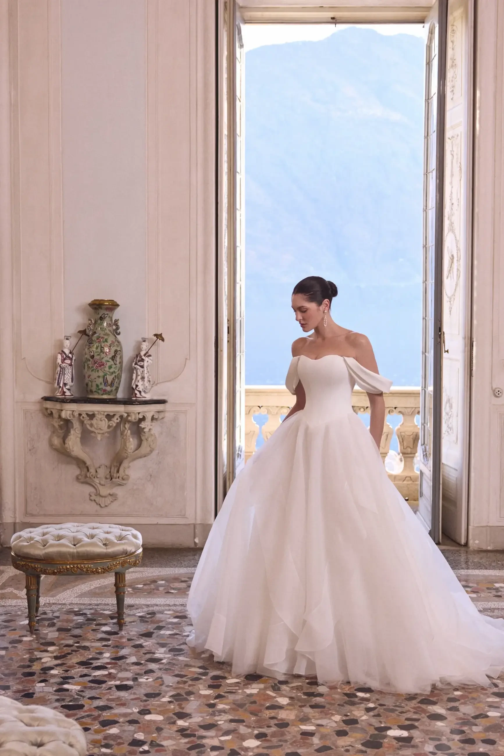 model is wearing an off the shoulder ball gown