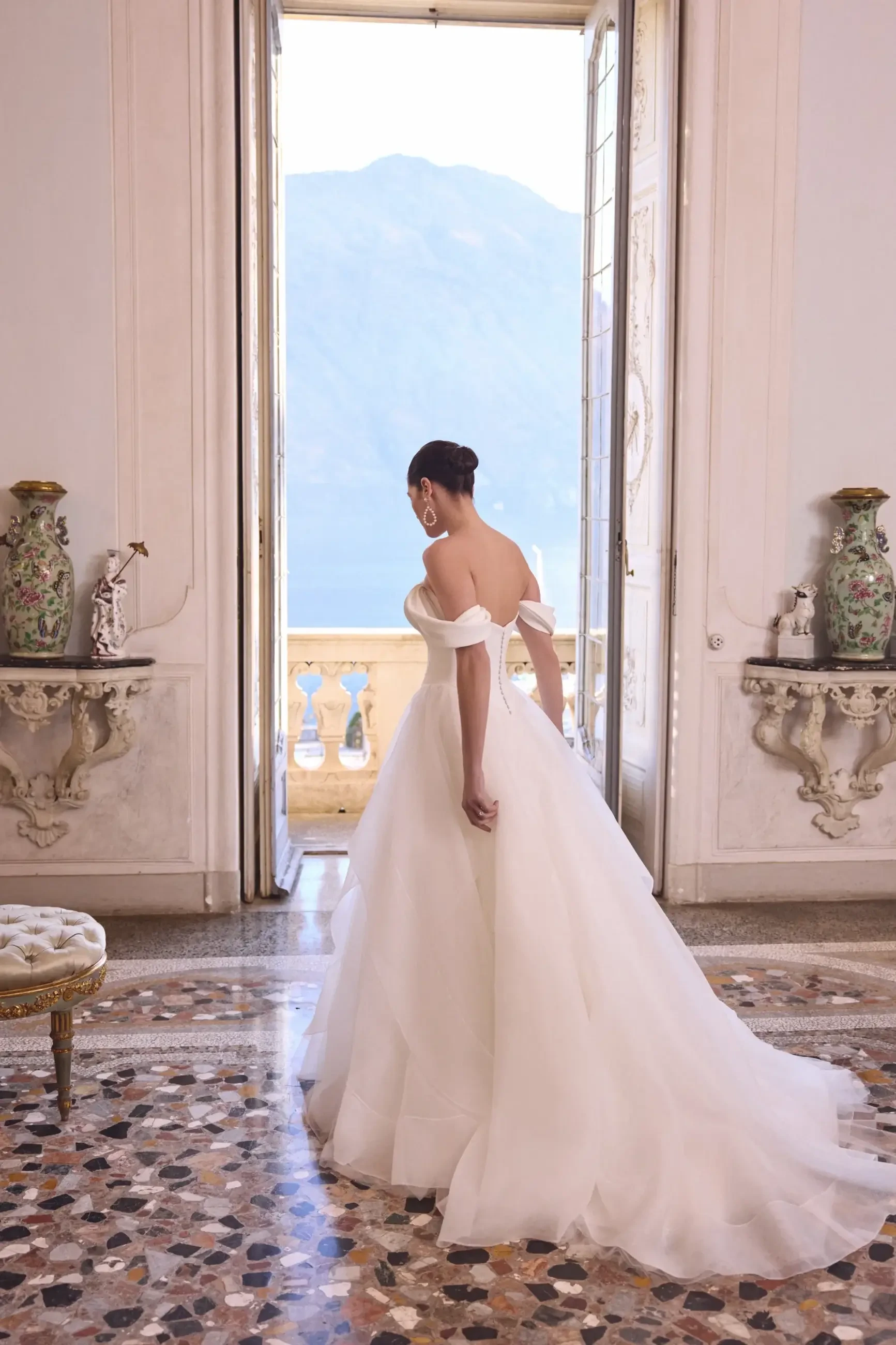 model is wearing an off the shoulder ball gown