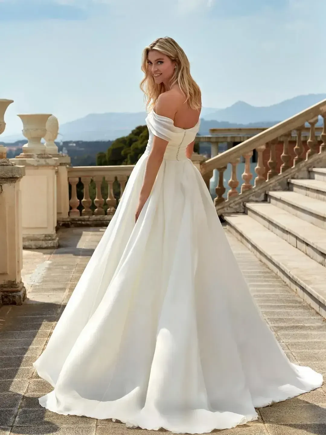 model is wearing an off the shoulder ball gown wedding dress