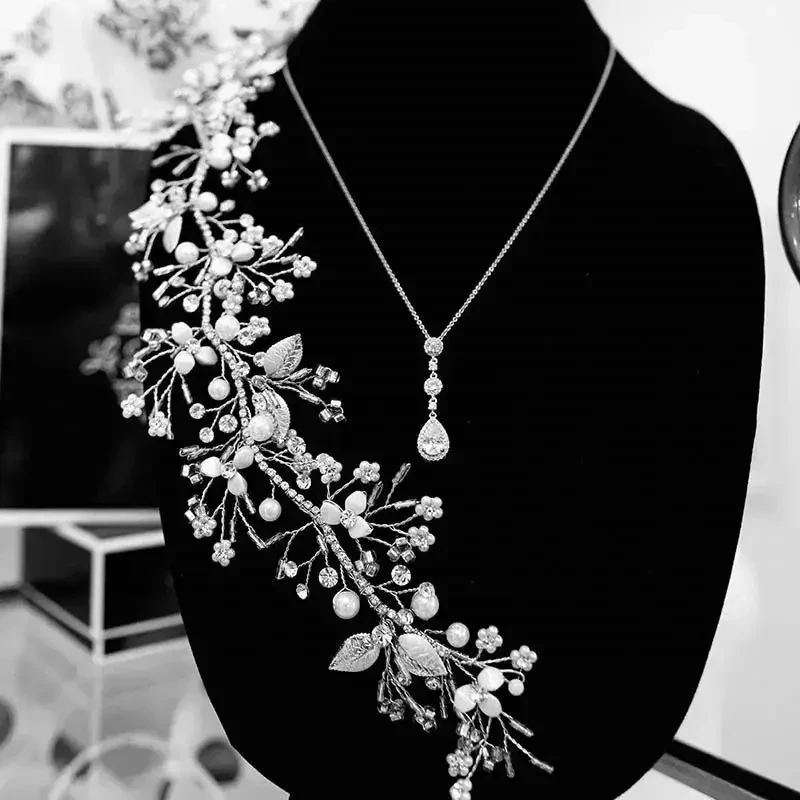 A close-up of an elegant necklace displayed on a black velvet bust, featuring intricate floral designs with beads and pearls.