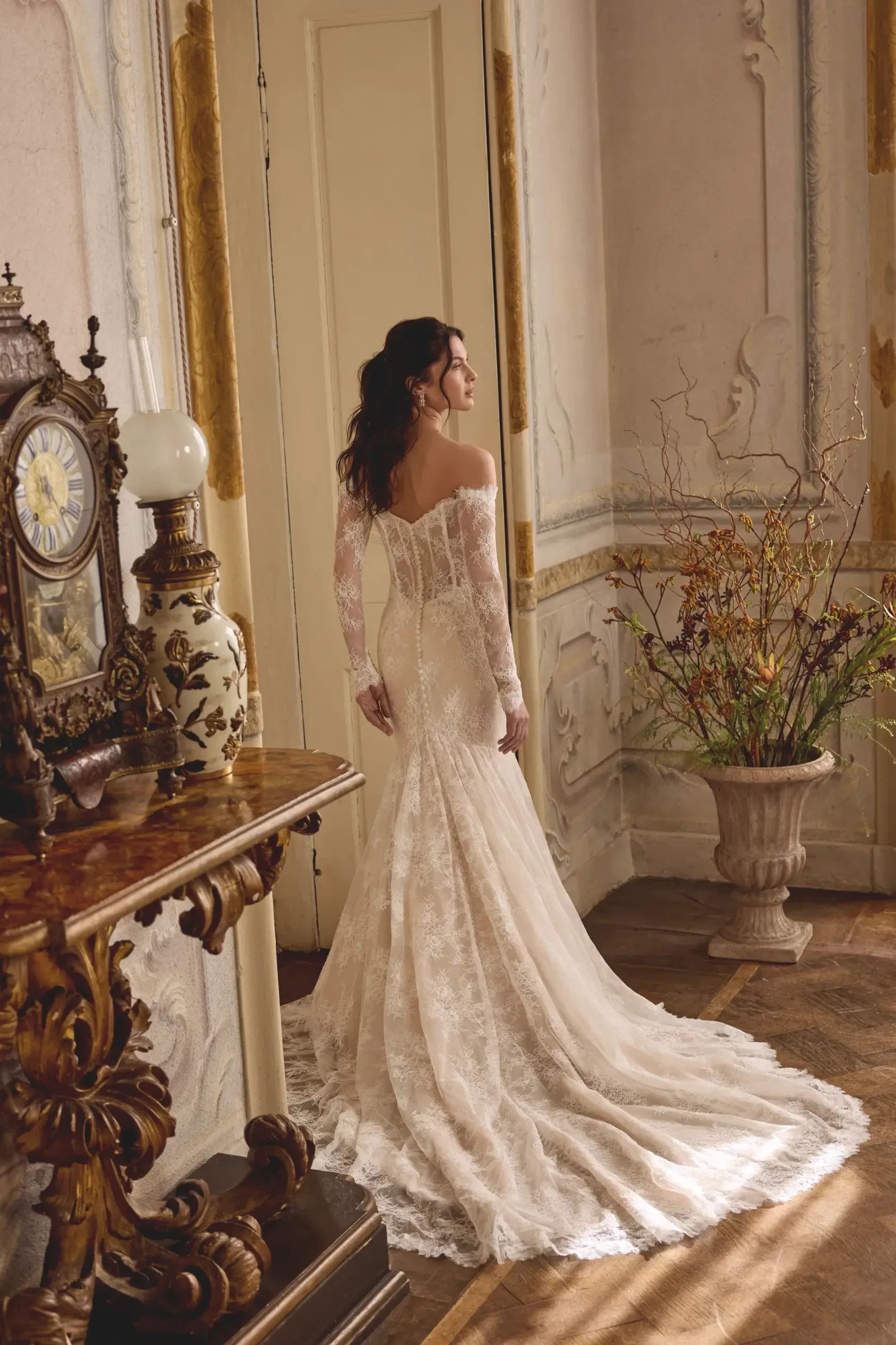 model is wearing an off the shoulder lace mermaid wedding dress