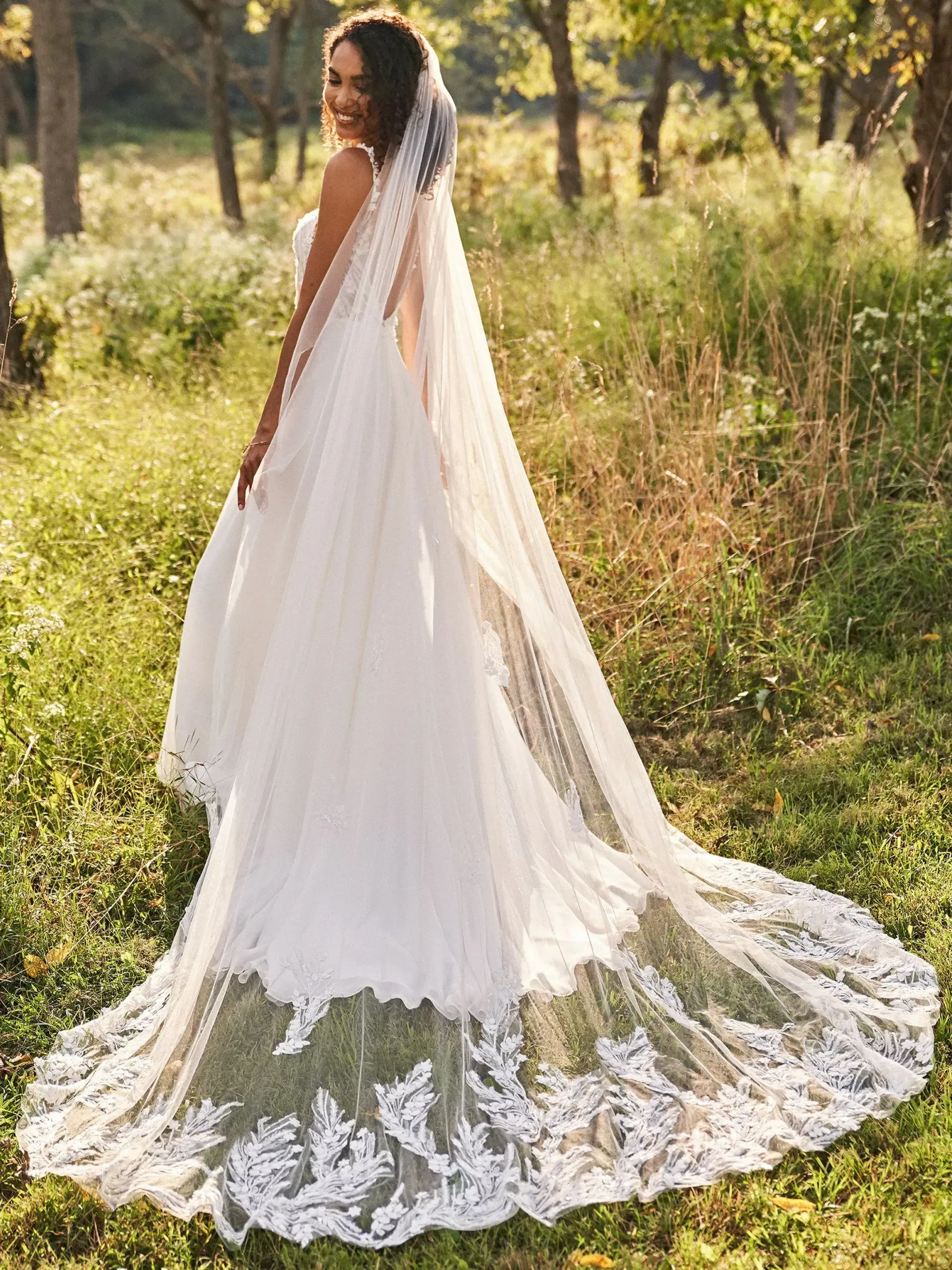 model is wearing a long bridal veil and wedding dress