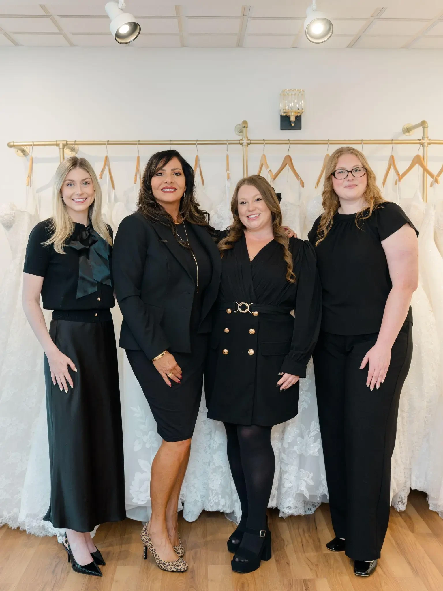 The Le Bella Donna bridal team standing together inside the Doylestown boutique, surrounded by wedding gowns.