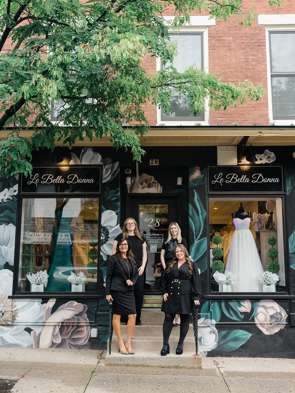 The Le Bella Donna bridal team standing outside the boutique’s floral-painted storefront in Doylestown, Pennsylvania.
